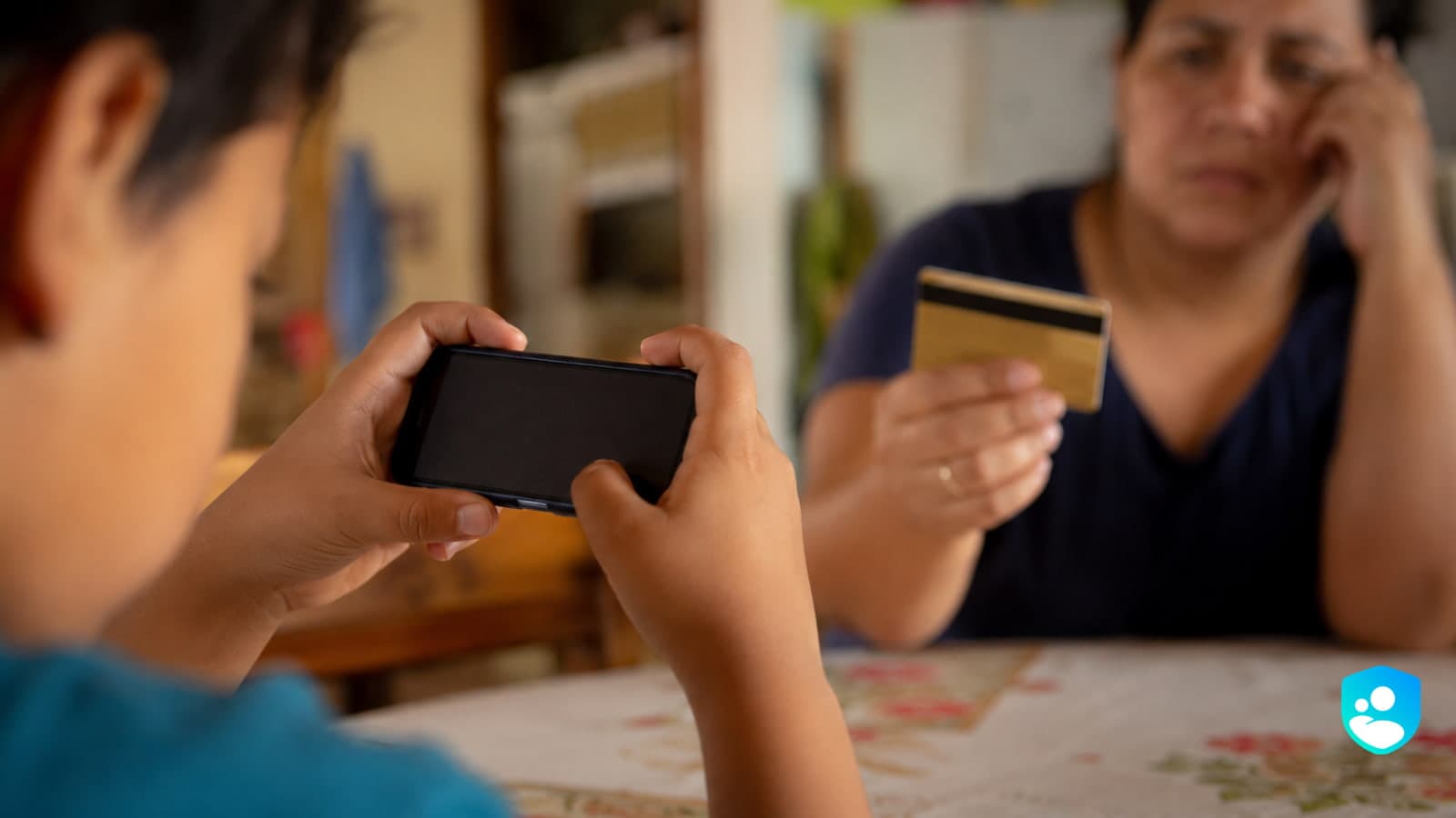 Un niño hace compras dentro del juego desde el celular con una tarjeta bancaria guardada